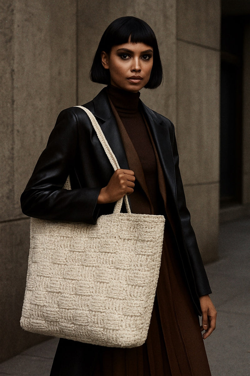 Woman holding a textured tote bag against a neutral background
